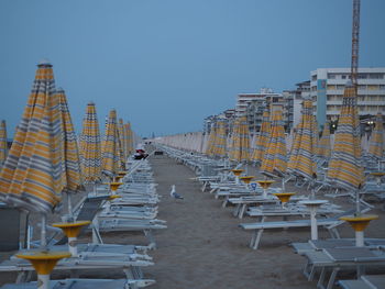 Panoramic shot of chairs on beach against buildings