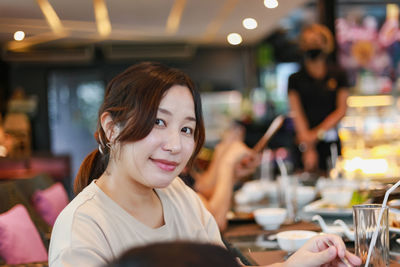 Portrait of young woman with drink in restaurant