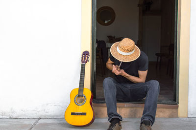 Midsection of man holding guitar