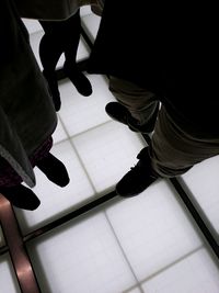 Low section of man standing on tiled floor