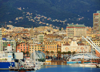 Cityscape by river against mountain