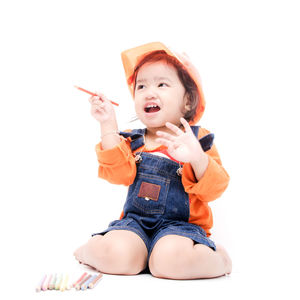 Portrait of cute baby girl sitting on white background