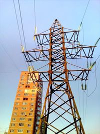 Low angle view of electricity pylon against clear sky