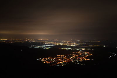 High angle view of illuminated cityscape against sky at night