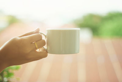 Close-up of hand holding coffee cup