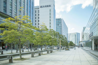 Footpath amidst buildings in city against sky