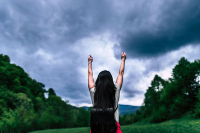 Rear view of woman standing against sky