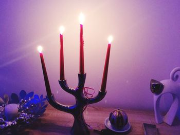 Close-up of lit candle in dark room