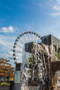 View of ferris wheel against cloudy sky