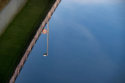 Reflection of bridge and road sign in water
