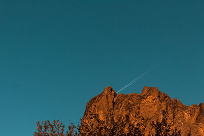 Low angle view of rock formation against clear blue sky
