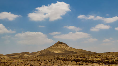 View of desert against cloudy sky