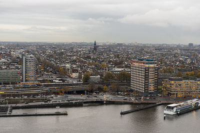 High angle view of river by buildings in city against sky