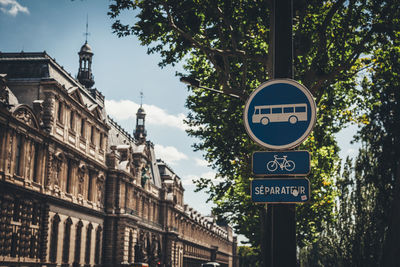 Road sign by historic building in city