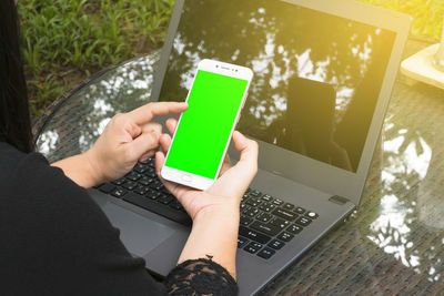 Midsection of woman using mobile phone