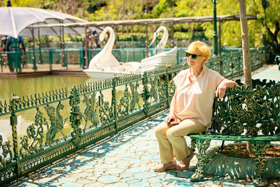 Mature beautiful woman traveler, sits on the bench of the park