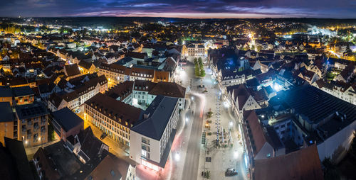 High angle view of illuminated street amidst buildings at night