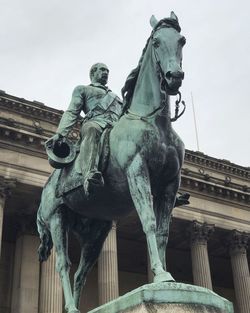 Low angle view of statue against built structure