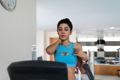 Young woman training at the gym using eliptical crosstrainer