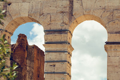 Low angle view of old ruin building against cloudy sky