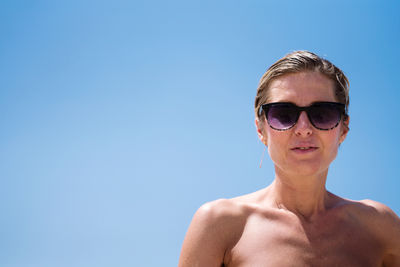 Low angle view woman with short hair enjoying sunshine wearing sunglasses