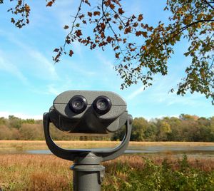 Close-up of camera on field against sky