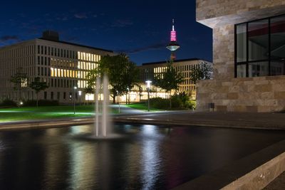 Illuminated buildings against sky at night