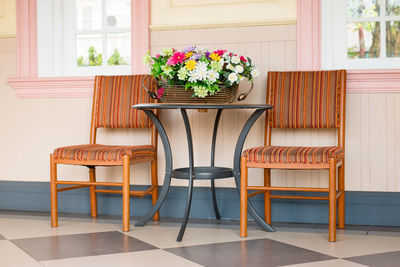 Flowers on table amidst chairs