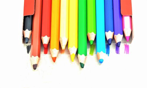 High angle view of colored pencils against white background