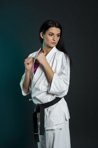 Young woman looking away against black background