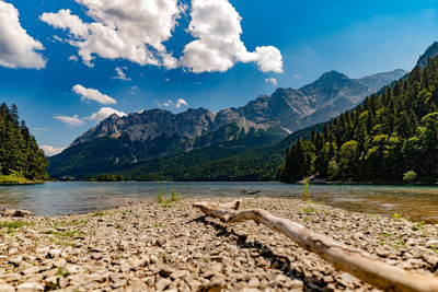 Scenic view of lake by mountains against sky