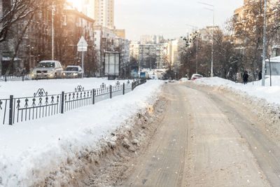 Snow covered road in city