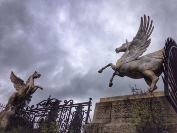 Low angle view of statue against cloudy sky