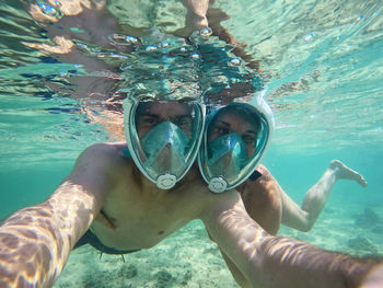 Midsection of man swimming in sea