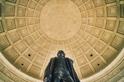 Low angle view of statue against cupola at thomas jefferson memorial