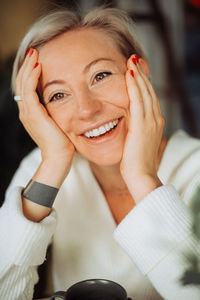 Close up of a blond woman with short hair and happy smile