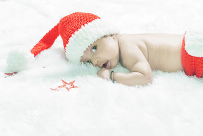 Portrait of cute girl lying down on snow