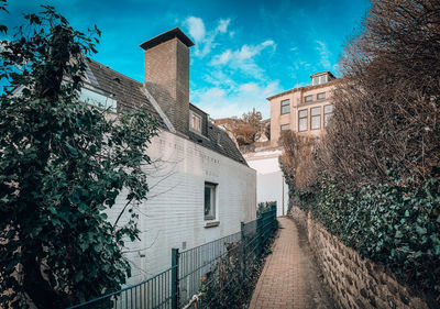 Footpath amidst buildings against sky
