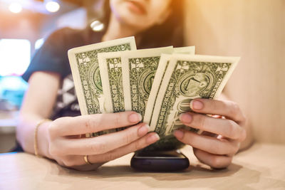 Close-up of woman holding dollar bills