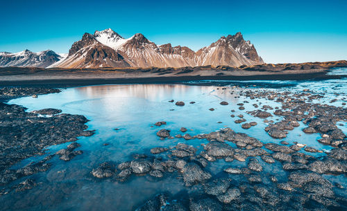 Scenic view of snowcapped mountains against blue sky