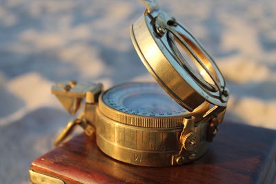 High angle view of compass with box on sand
