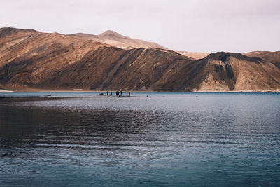 Scenic view of sea and mountains against sky