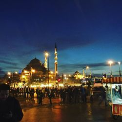 People at illuminated temple against sky at night