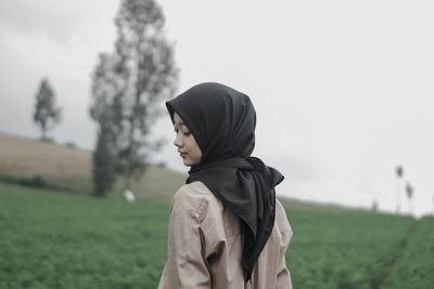 Side view of woman standing on field