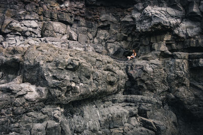 Woman sitting on rock formation