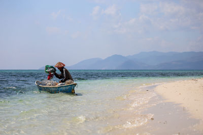 Man in boat on sea against sky