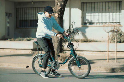 Portrait of trendy teenager boy cycling