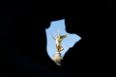Low angle view of angel statue against black background