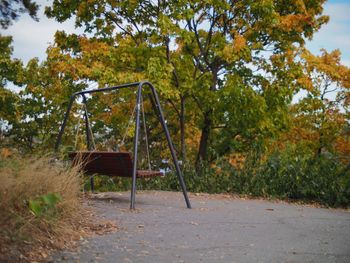 Playground by trees against sky