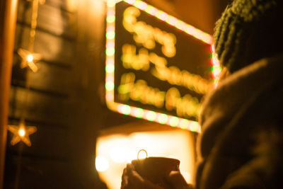 Close-up of man holding lit candles